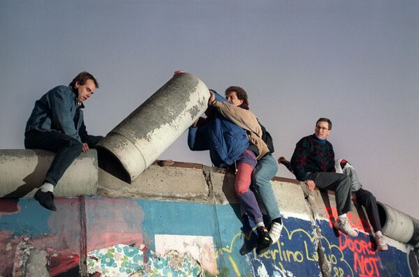 Жители Западного Берлина разбирают Берлинскую стену 16 ноября 1989 года