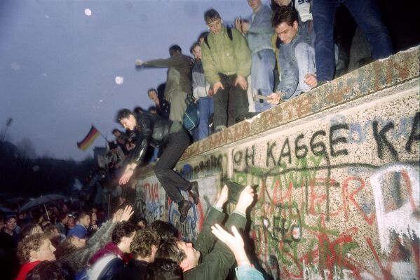 Жители Восточной Германии приветствуют граждан Западной Германии у Бранденбургских ворот в Берлине 22 декабря 1989 года