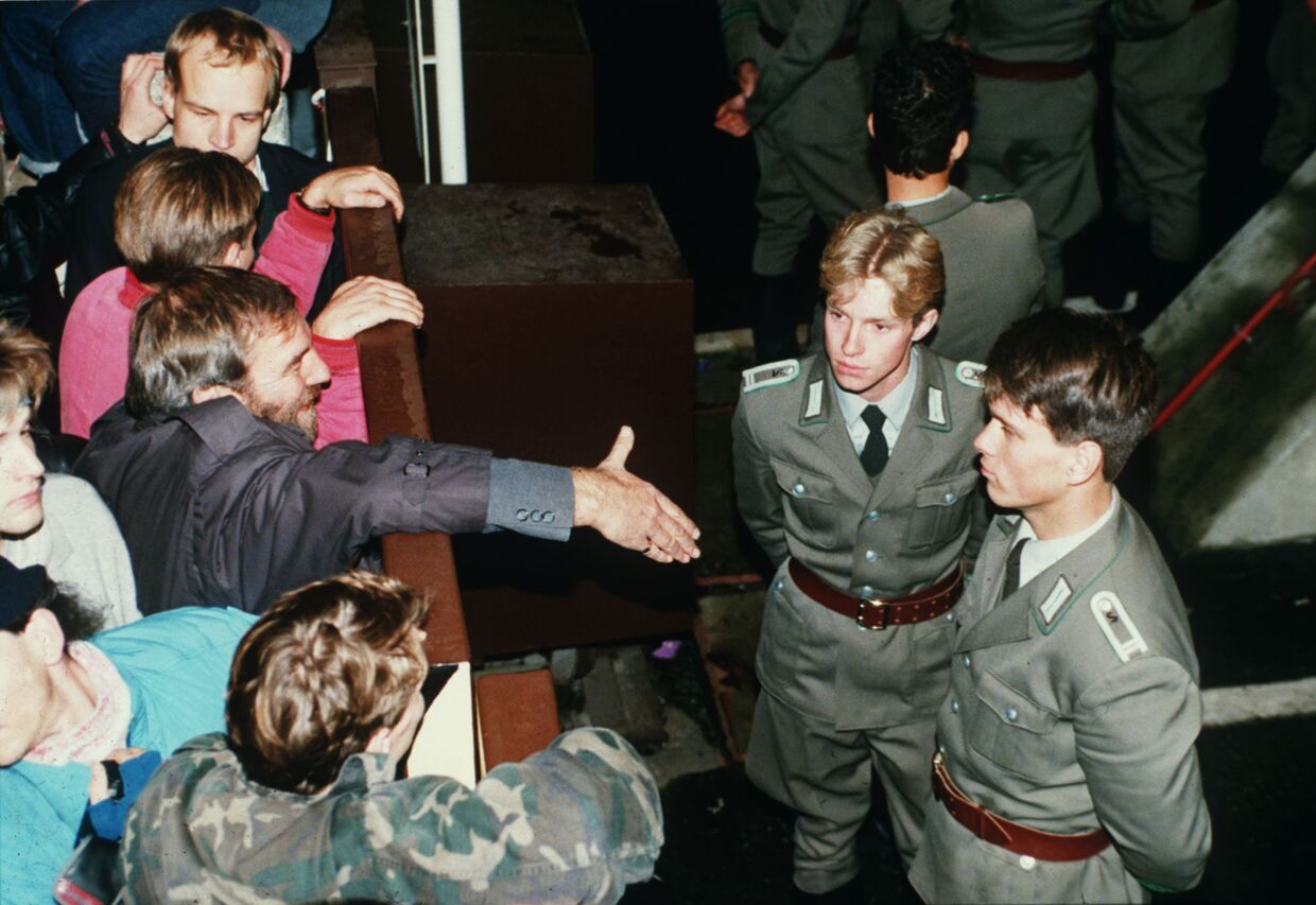 Восточногерманские пограничники отказываются пожать руку берлинцу на контрольно-пропускным пункте Чарли