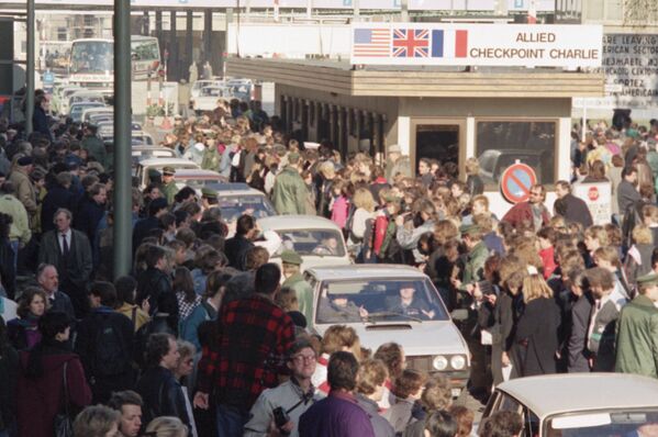 Граждане Восточного Берлина пересекают контрольно-пропускной пункт Чарли, чтобы посетить Западный Берлин в ноябре 1989 года