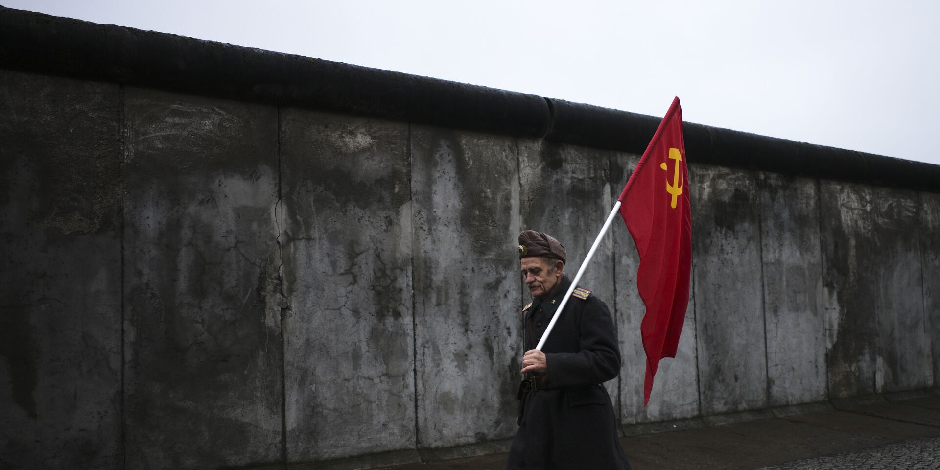 Пожилой человек с советским флагом на фоне Берлинской стены - ИноСМИ, 1920, 29.12.2021