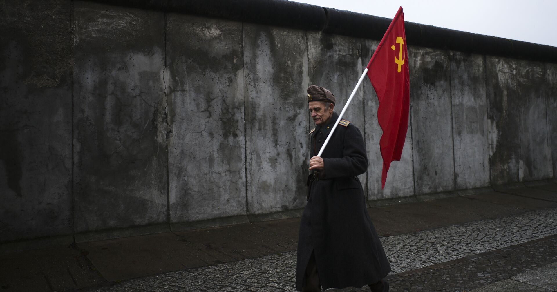 Пожилой человек с советским флагом на фоне Берлинской стены - ИноСМИ, 1920, 29.12.2021