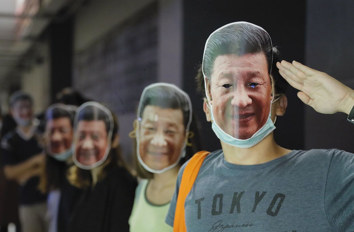 Протестующие в масках председателя КНР Си Цзиньпина во время беспорядков в Гонконге