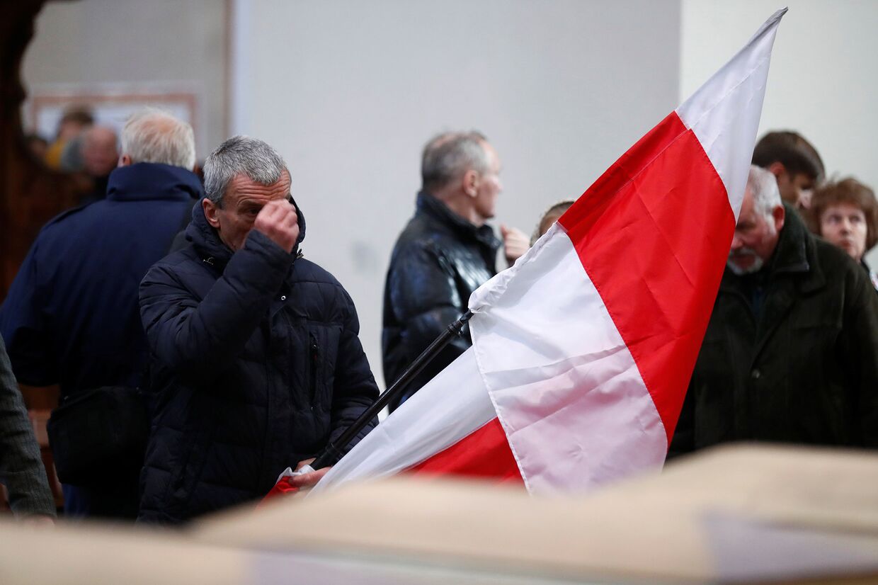 Мужчина держит польский флаг в Вильнюсе, Литва