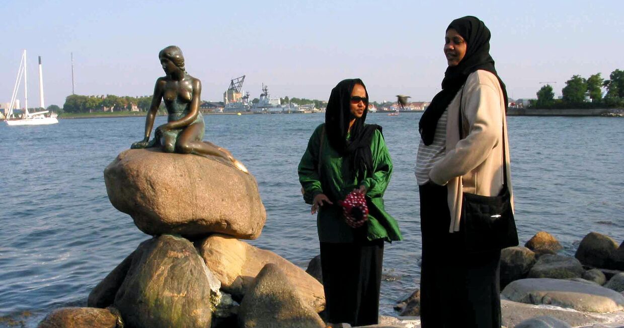 Сомалийские беженцы, живущие в Дании у статуи русалочки в Копенгагене