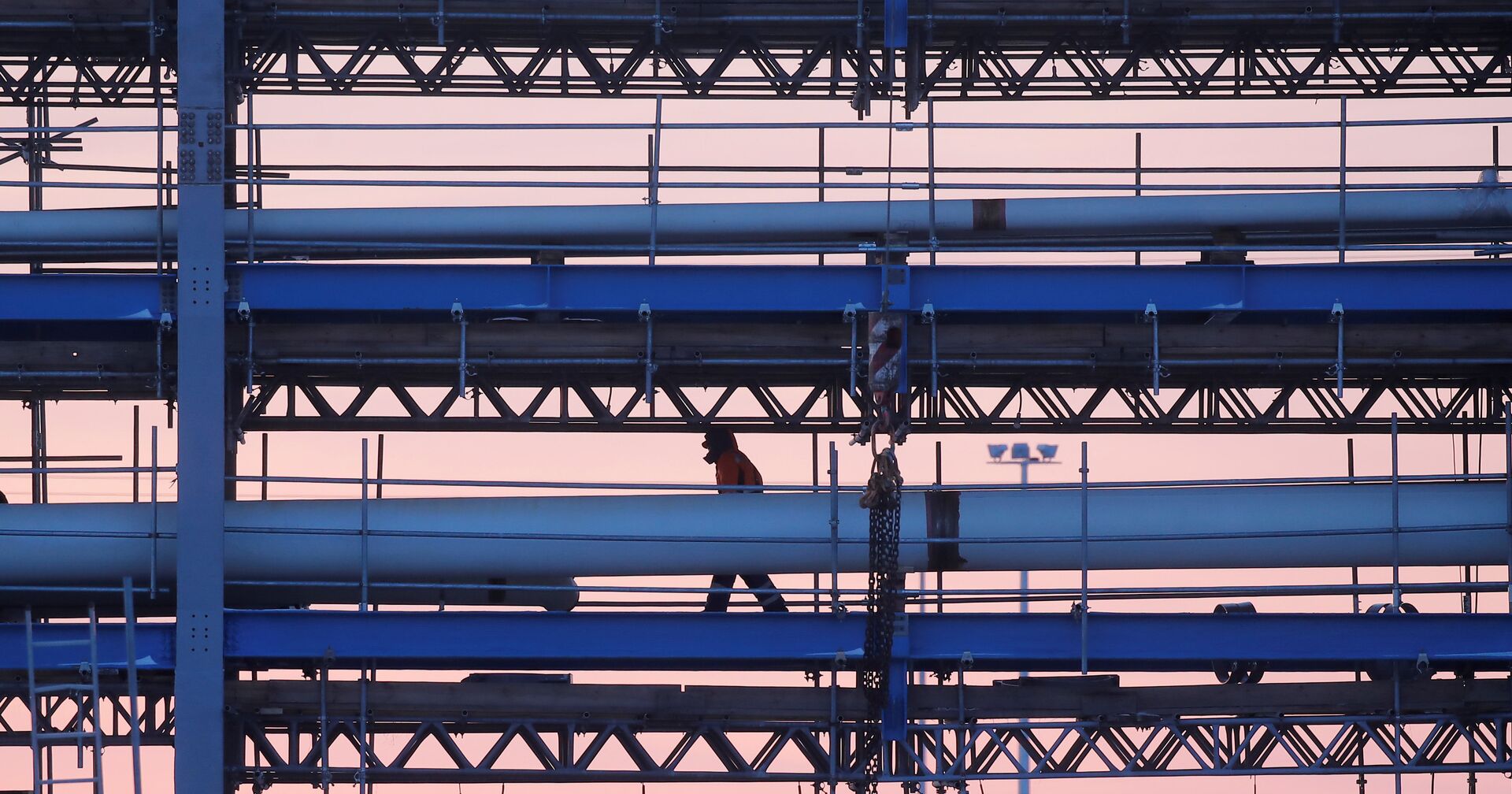 Строитель идет по мосту с трубопроводами на стройплощадке Амурского газоперерабатывающего завода, входящего в проект «Сила Сибири» Газпрома - ИноСМИ, 1920, 14.10.2021