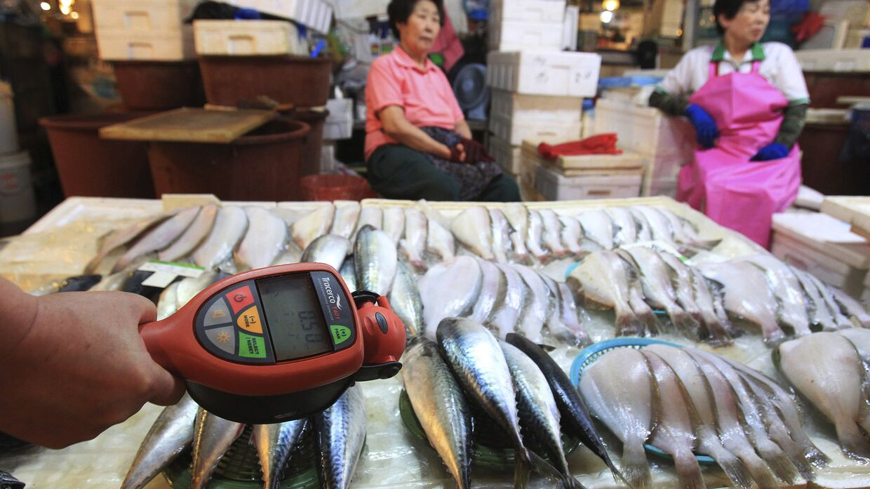 Проверка радиактивного загрязнения с помощью счетчика Гейгера на рыбном рынке в Сеуле, Южная Корея