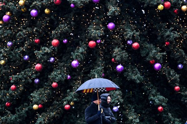 Прохожие у рождественской елки в Москве