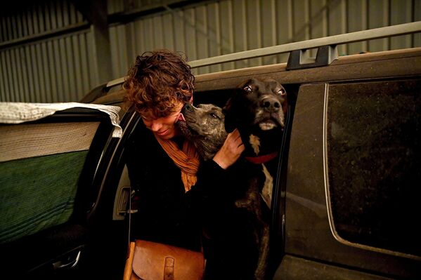Женщина с собаками в эвакуационном центре в Кобарго, Австралия