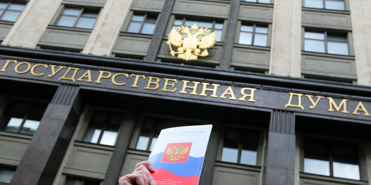 Конституция Российской Федерации на фоне здания Государственной Думы РФ в Москве