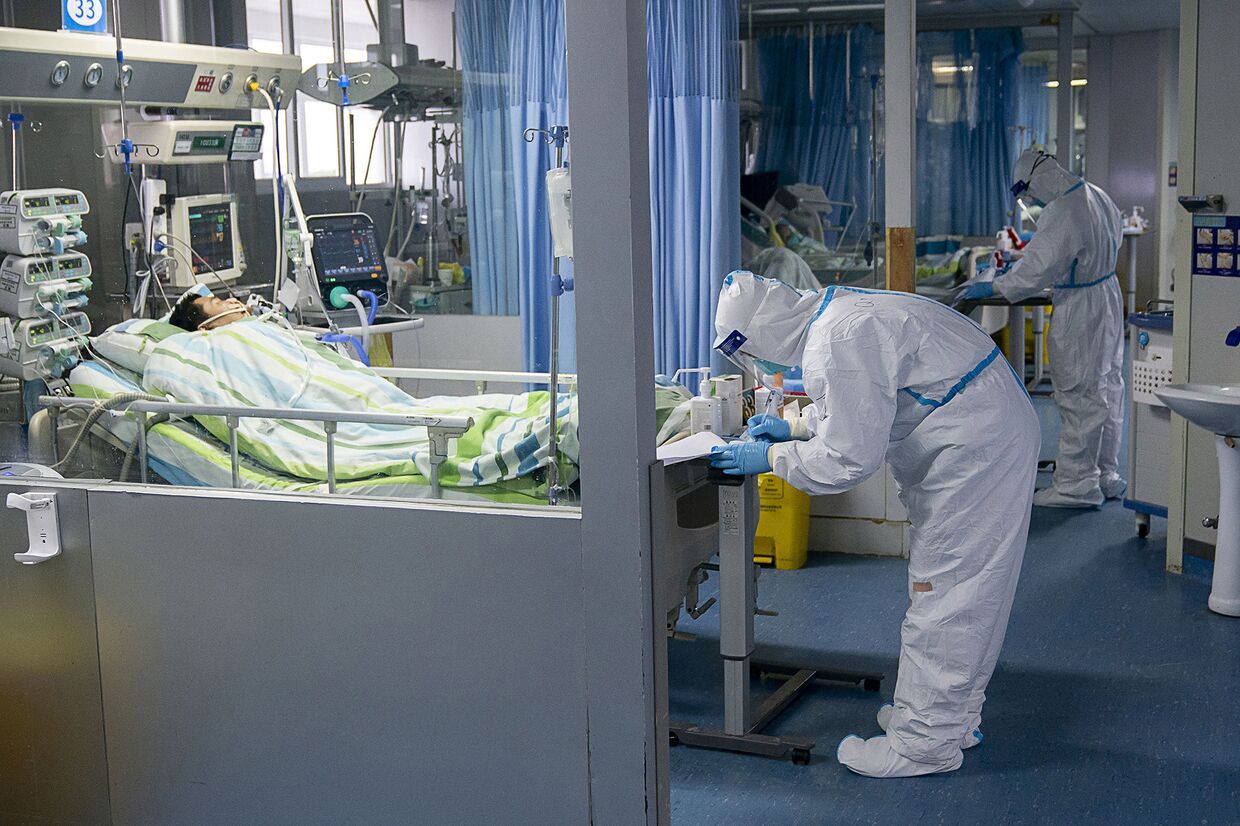 Медицинский персонал ухаживает за больным в палате Чжуннань Уханьского университета в Ухане, Китай
