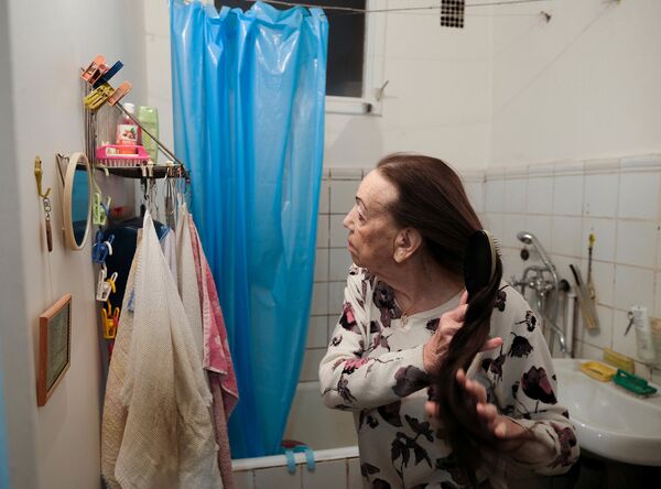 Майя Качина расчесывает волосы дома в Москве