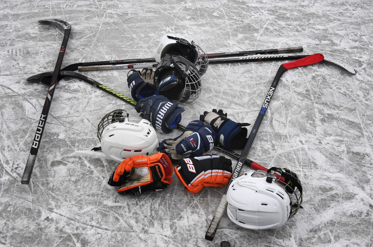 Клюшки, шлемы и перчатки на льду