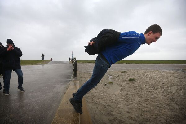 Мужчина балансирует на краю дамбы во время урагана Киара в Харлингене