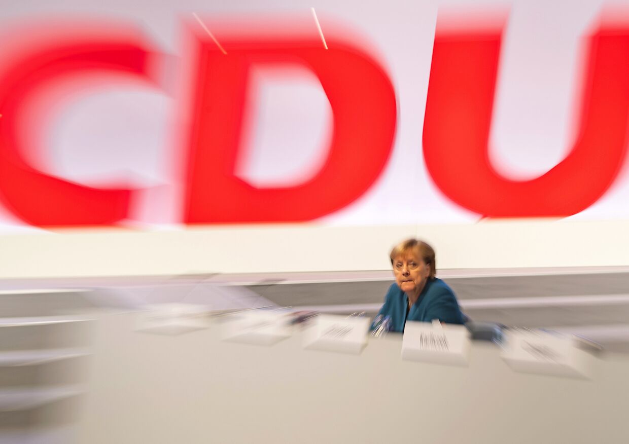 Канцлер Германии Ангела Меркель на фоне логотипа партии ХДС