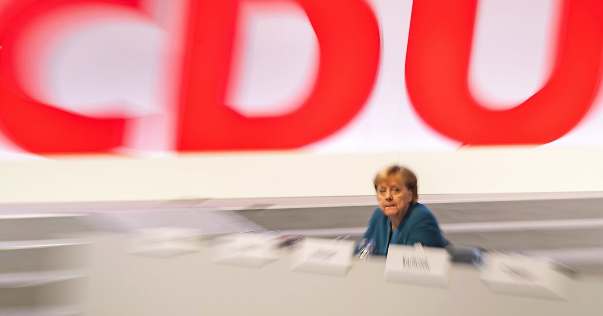 Канцлер Германии Ангела Меркель на фоне логотипа партии ХДС