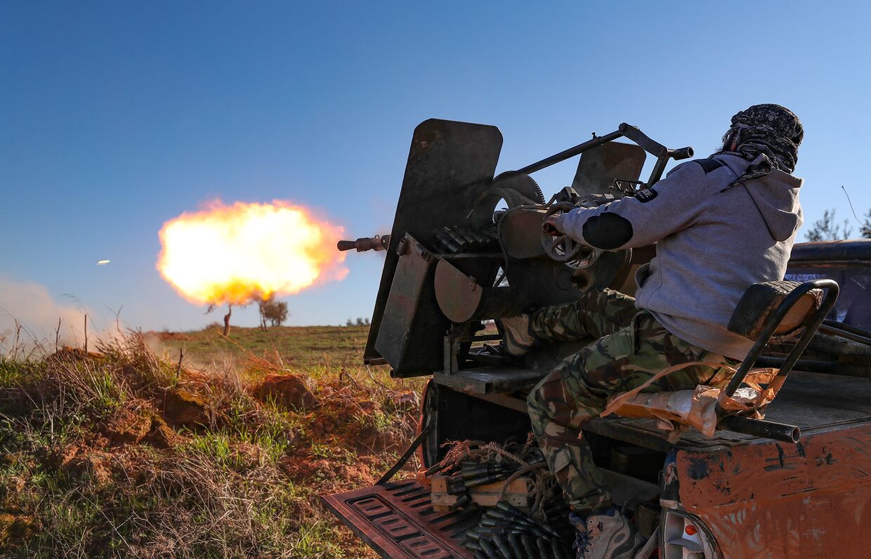 Сирийский боевик обстрелдивает позиции правительственных войск в провинции Идлиб