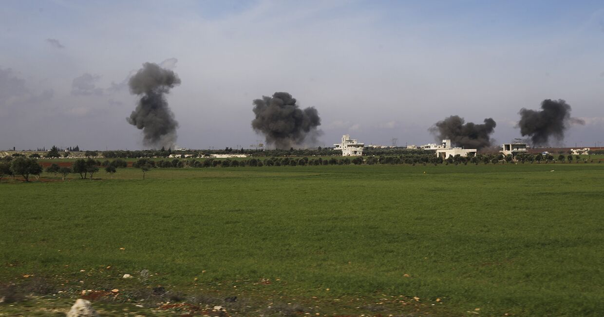 Столбы дыма после авиаударов по городу Саракеб в провинции Идлиб, Сирия