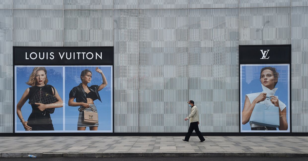 Мужчина идет мимо магазина Louis Vuitton в Ухане, Китай