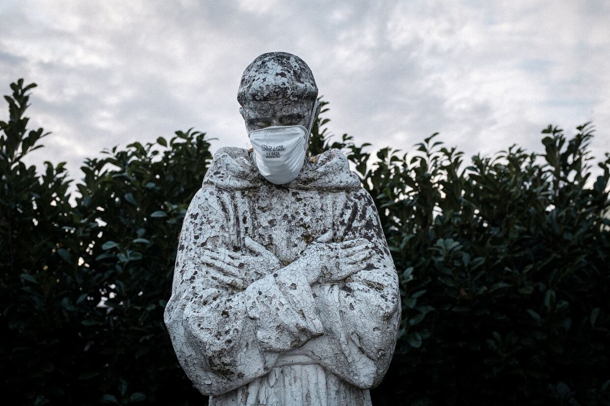 Маска на лице статуи в городе Сан-Фьорано, Италия