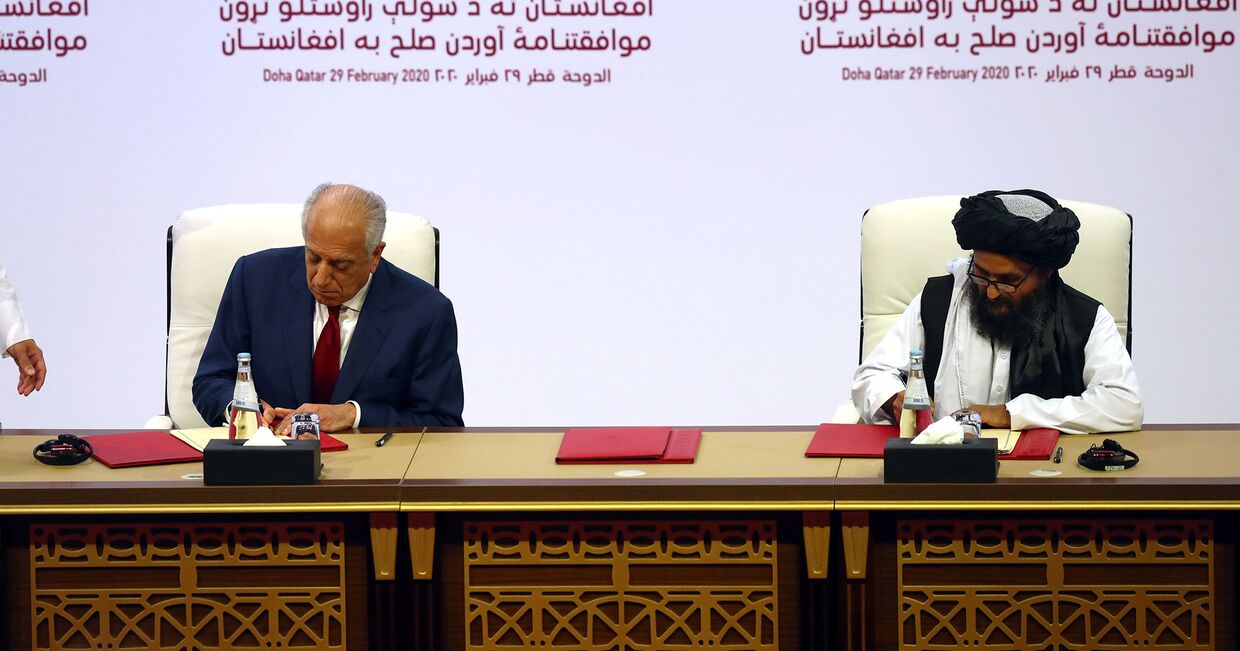 Мулла Абдул Гани Барадар и Залмаем Халилзад на церемонии подписания соглашения в Дохе, Катар