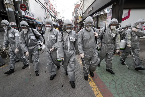 Солдаты в защитных костюмах распыляют дезинфицирующее средство в Сеуле, Южная Корея
