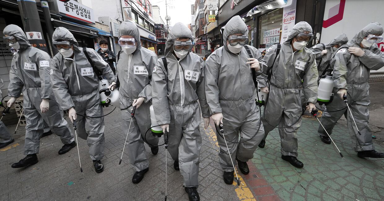 Солдаты в защитных костюмах распыляют дезинфицирующее средство в Сеуле, Южная Корея