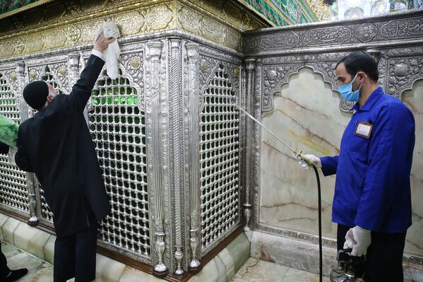 Работники проводят дезинфекцию храма Масуме в Куме, Иран