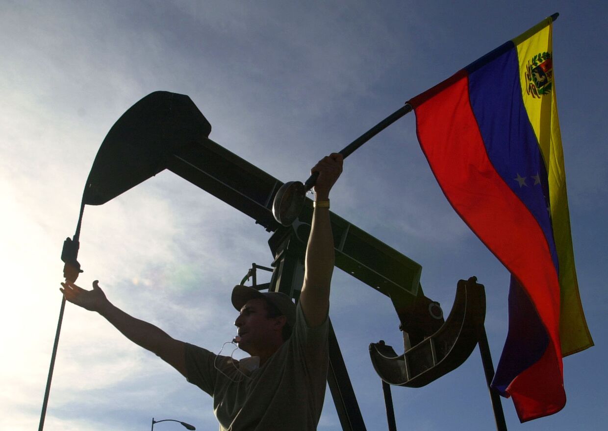 Флаг Венесуэлы у нефтяной вышки в Каракасе