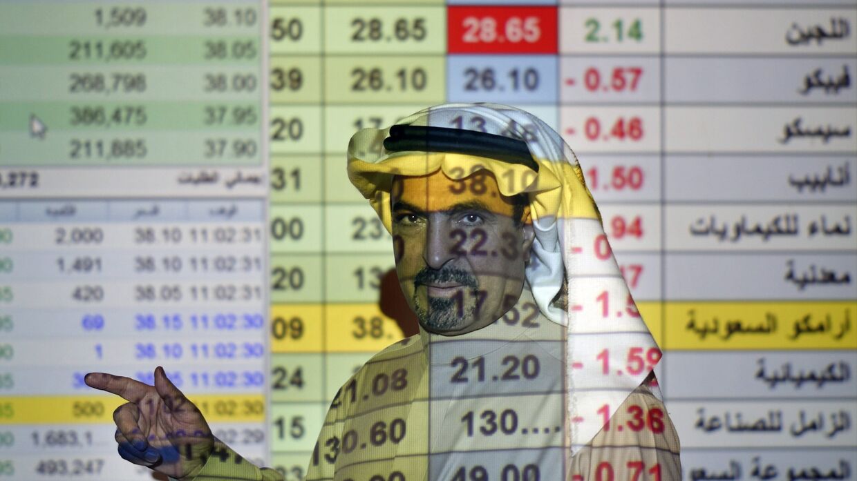 Трейдер говорит о ценах на нефть в банке в Эр-Рияде, Саудовская Аравия