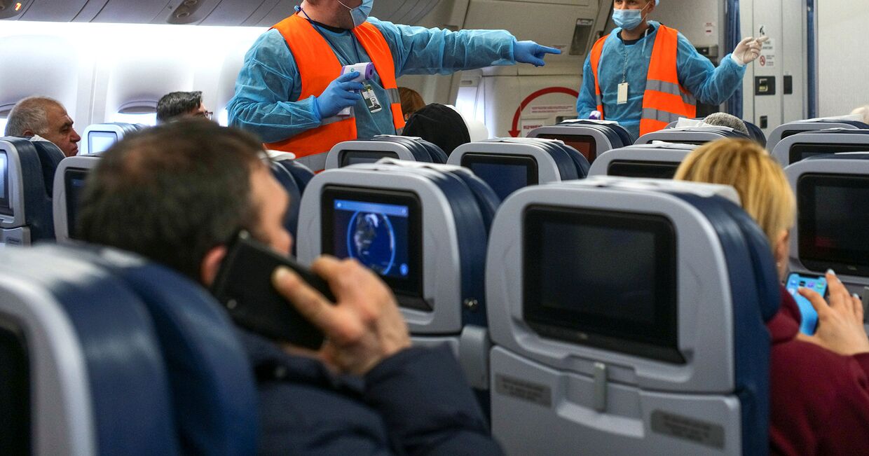 Медицинские работники во время измерения температуры тела пассажиров в Международном аэропорту Борисполь под Киевом, Украина