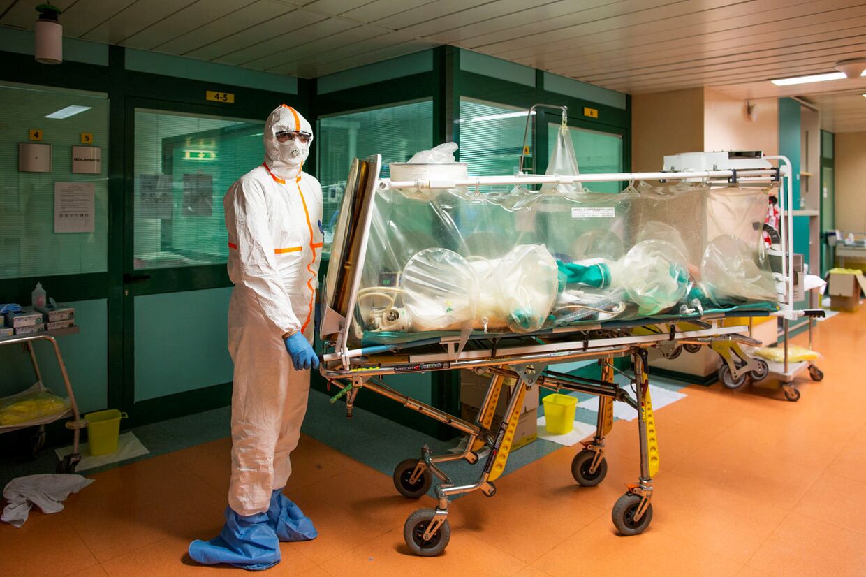 Медицинский работник в защитных костюмах переводят пациента с коронавирусом в больнице Гемелли в Риме, Италия