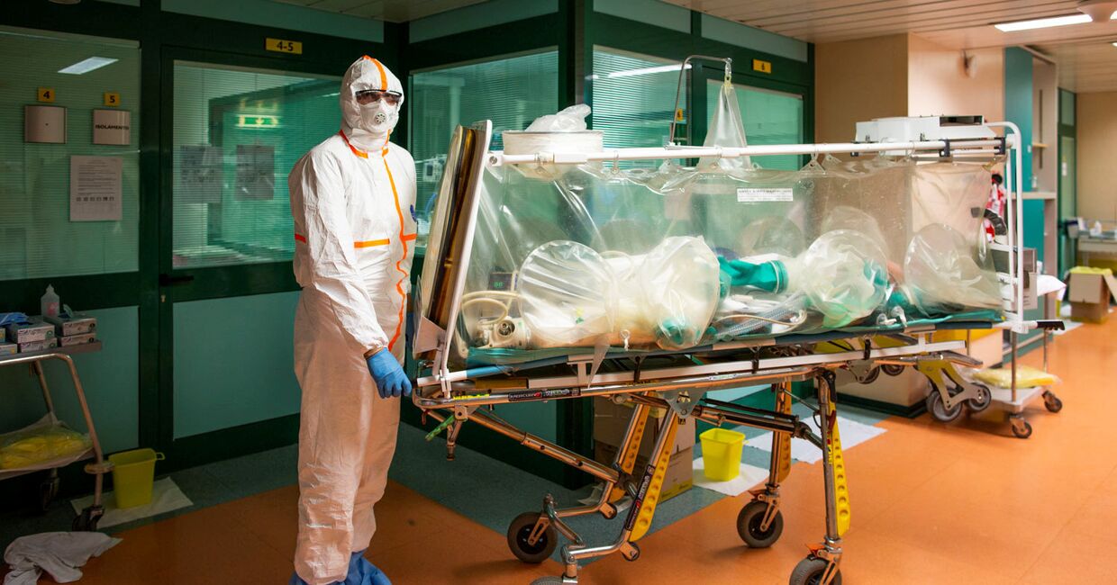 Медицинский работник в защитных костюмах переводят пациента с коронавирусом в больнице Гемелли в Риме, Италия