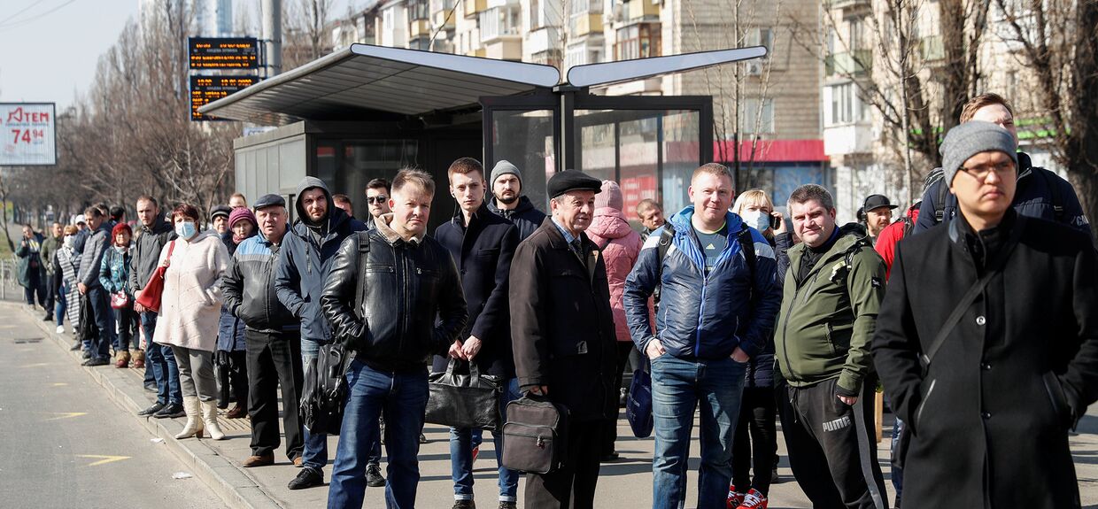 Пассажиры на остановке общественного транспорта в Киеве, Украина