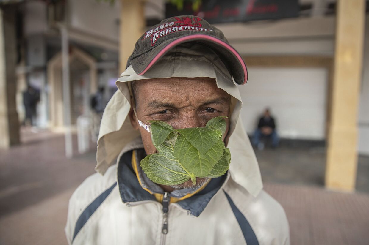 Уличный торговец в самодельной маске из фиговых листьев в Медине, Марокко