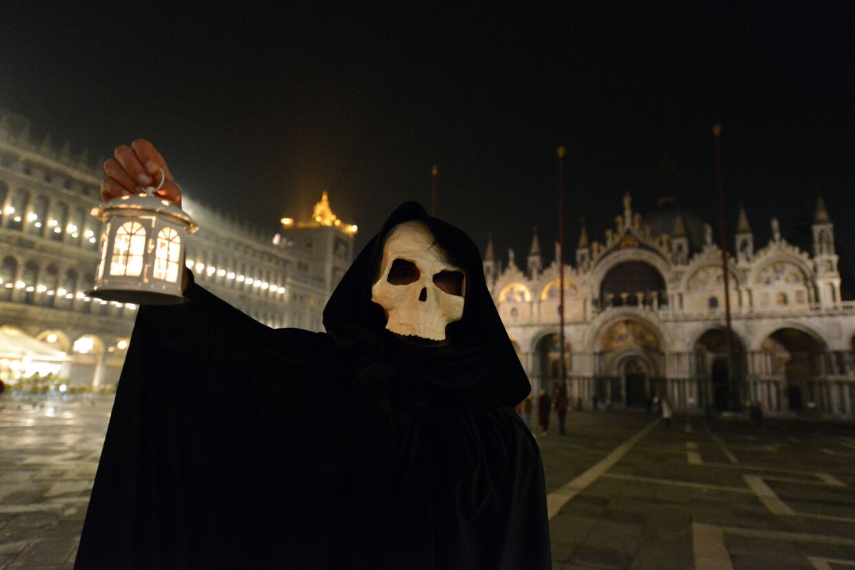 Человек в костюме Смерти на пустой Площади святого Марка в Венеции, Италия