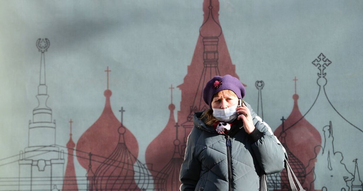 Женщина в медицинской маске на одной из улиц в Москве