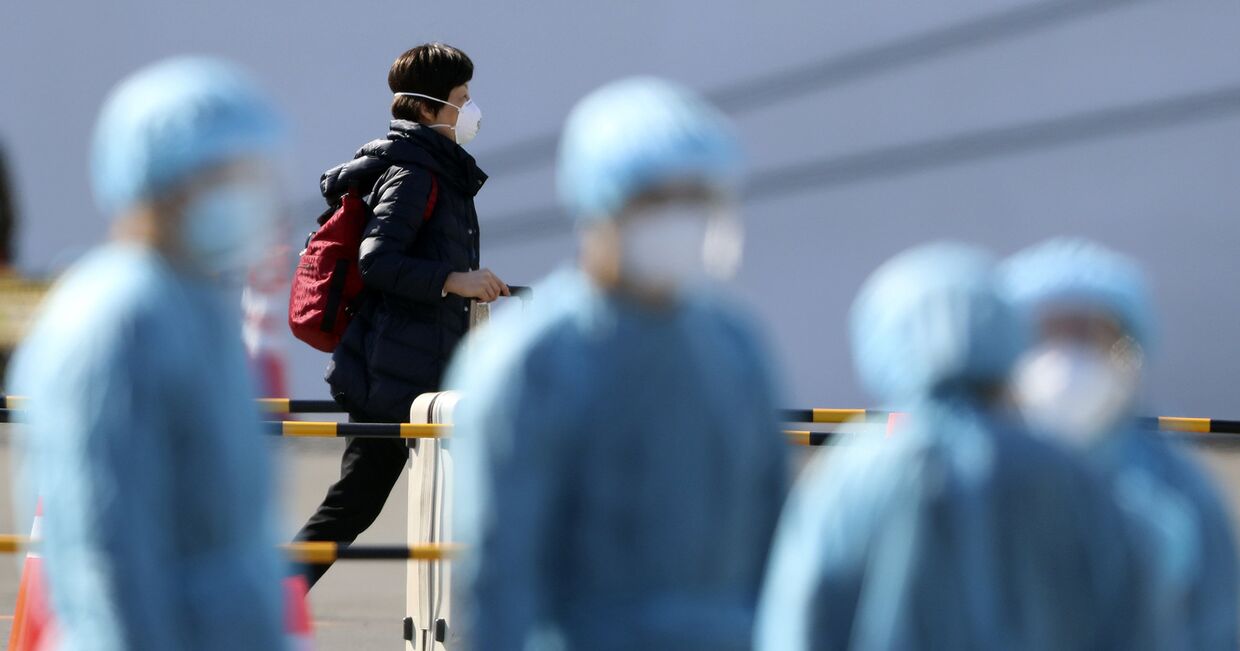 Пассажир и медицинский персонал в порту Иокогамы, недалеко от Токио