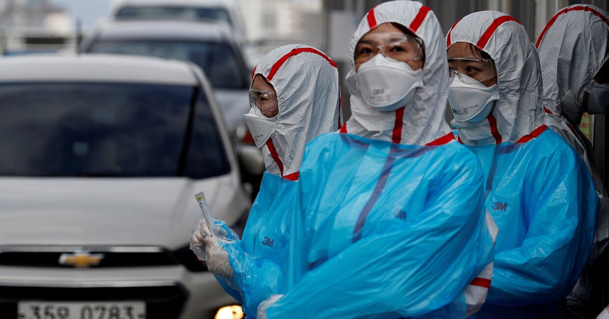Медицинский персонал в защитном снаряжении в медицинском центре Университета Юннам в Тэгу, Южная Корея