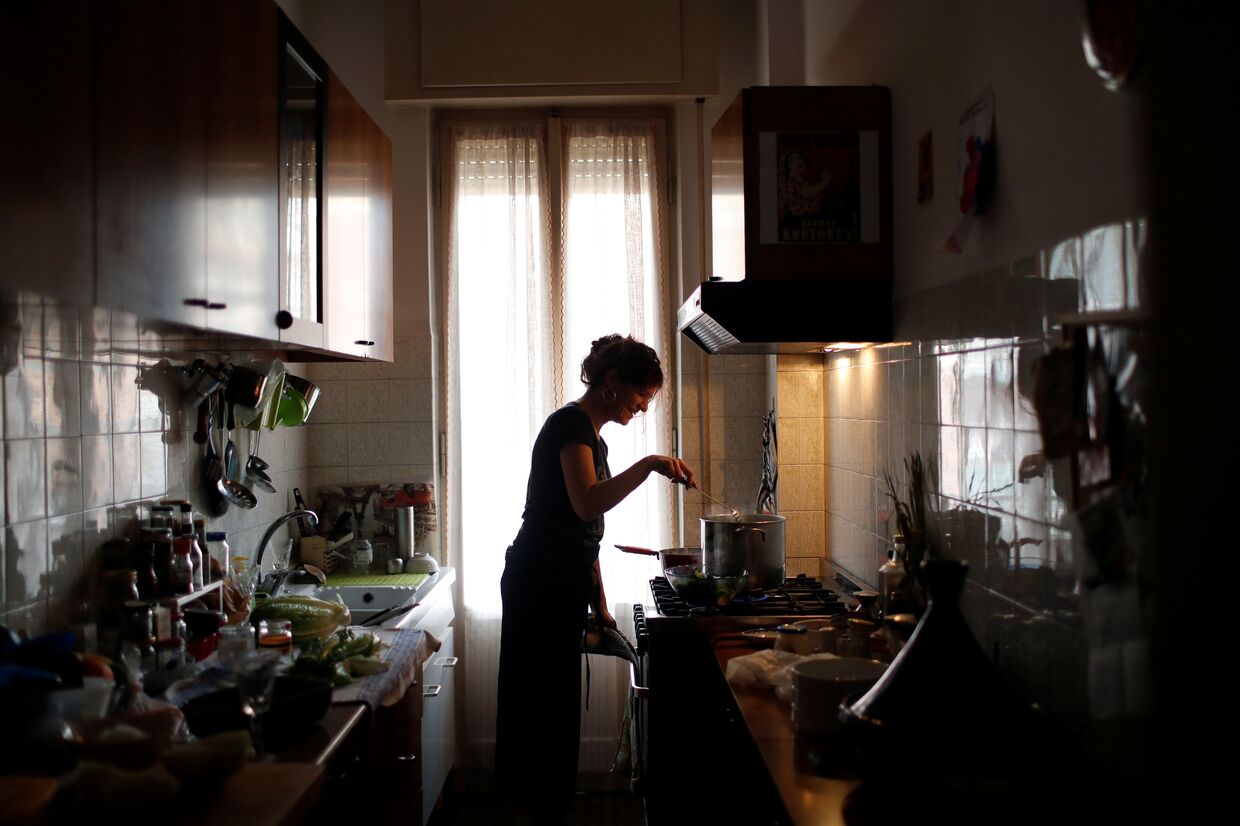 Женщина на кухне готовит еду, Рим, Италия