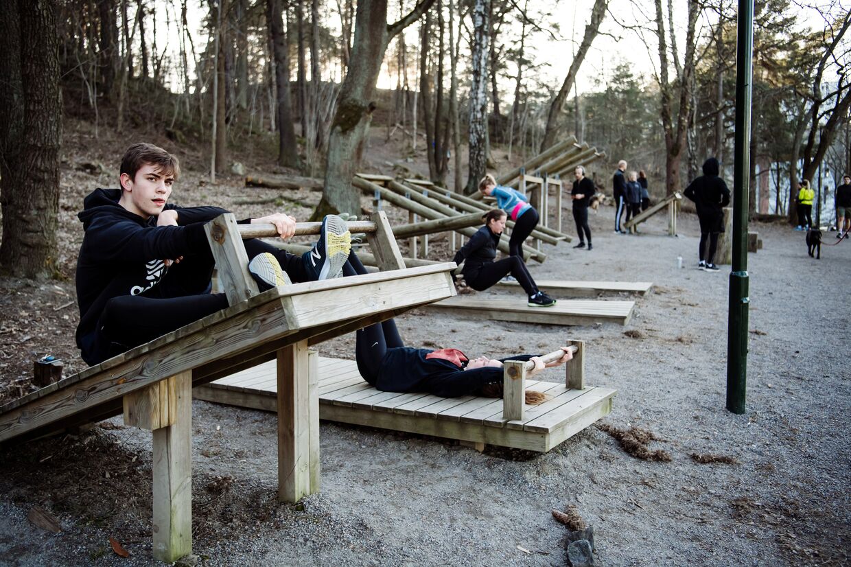 Молодые люди упражняются в парке, Стокгольм, Швеция