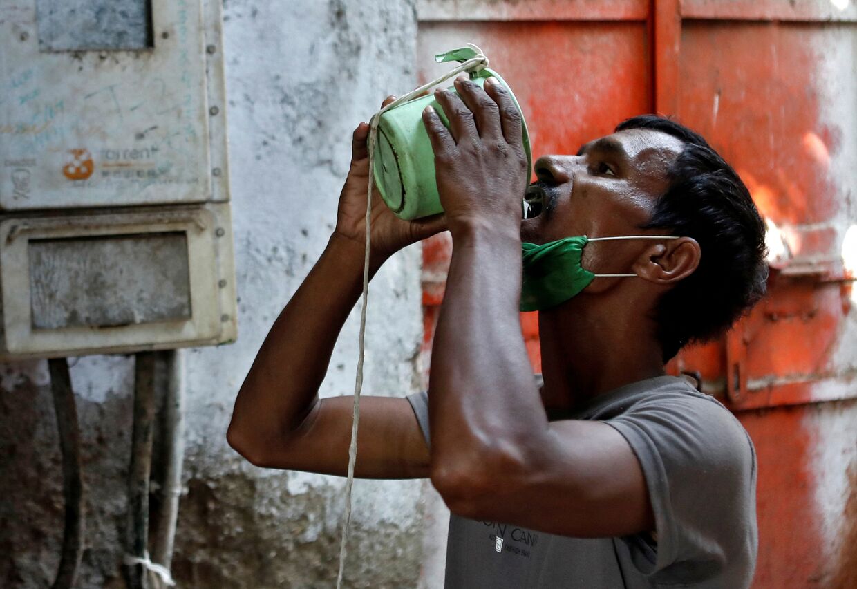 1 апреля 2020. Мужчина пьет воду в пригороде Мумбаи, Индия