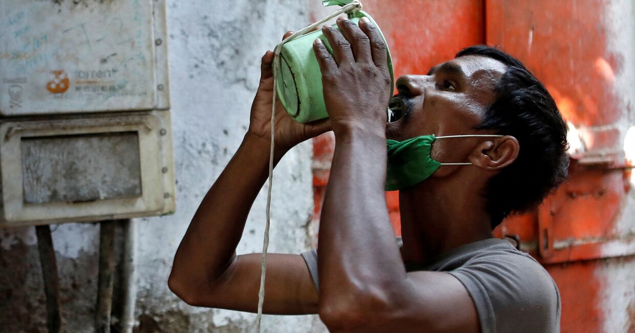 1 апреля 2020. Мужчина пьет воду в пригороде Мумбаи, Индия