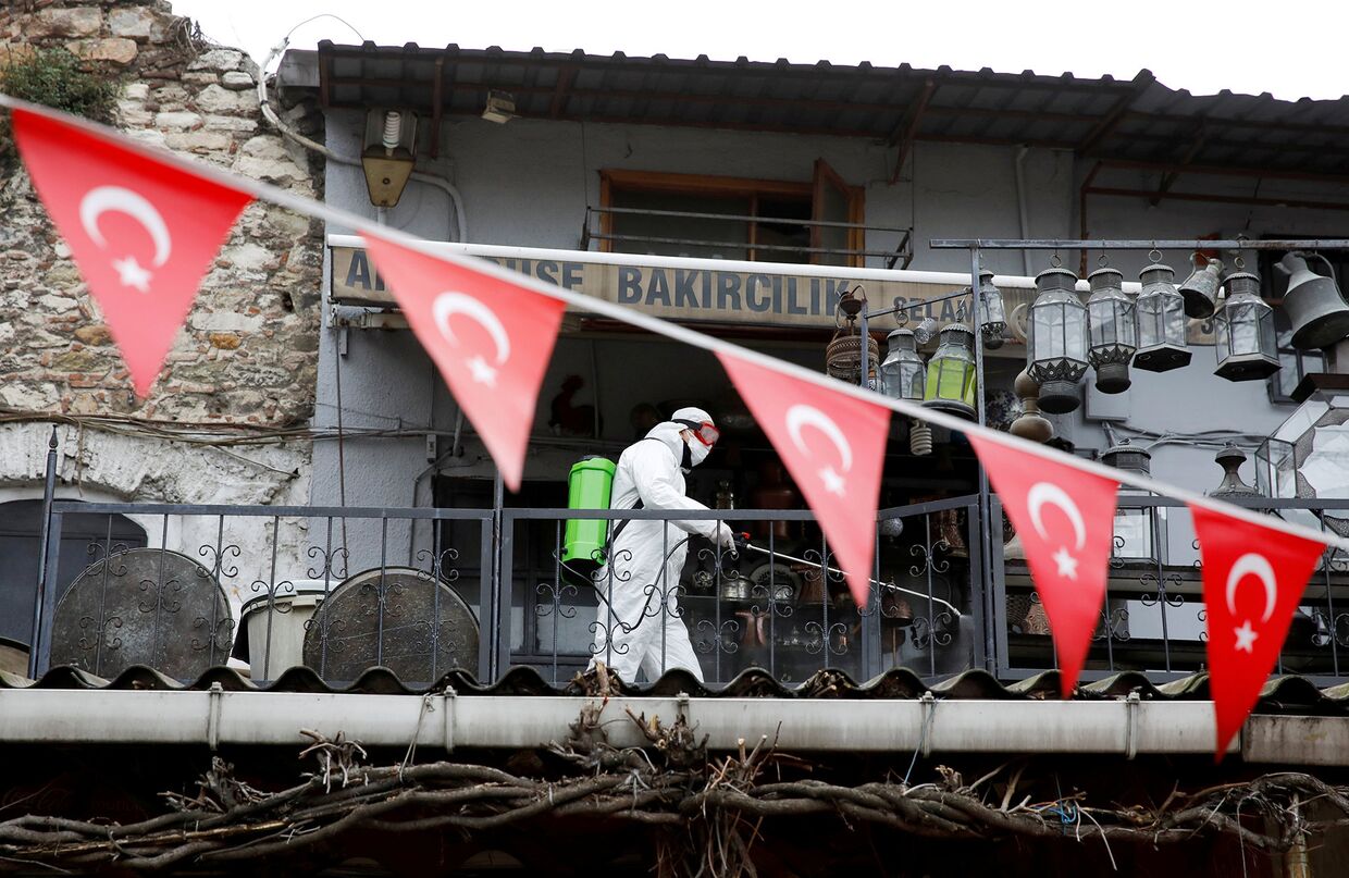 Рабочий распыляет дезинфицирующее средство на Гранд-Базаре в Стамбуле, Турция
