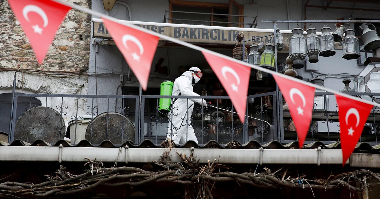 Рабочий распыляет дезинфицирующее средство на Гранд-Базаре в Стамбуле, Турция