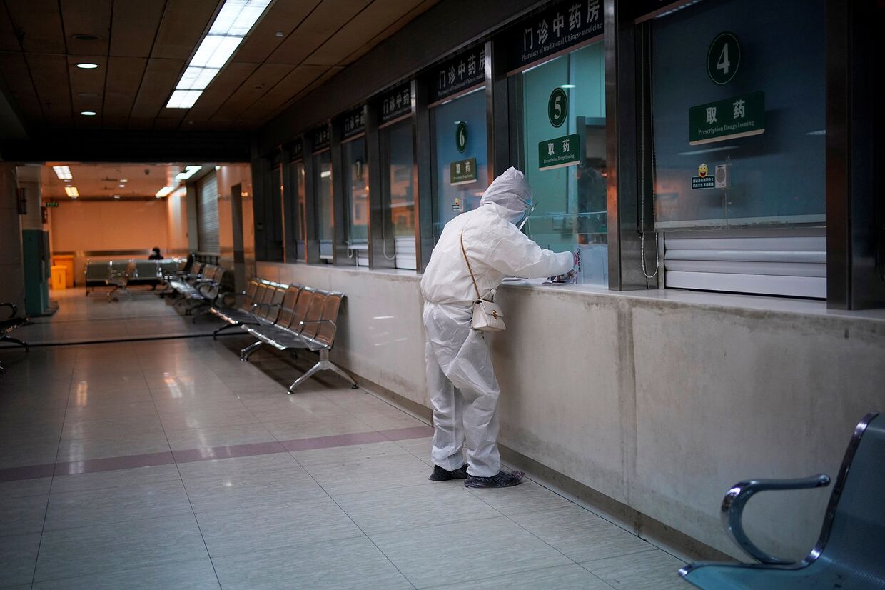 Женщина в защитном костюме в больнице в Ухане, Китай