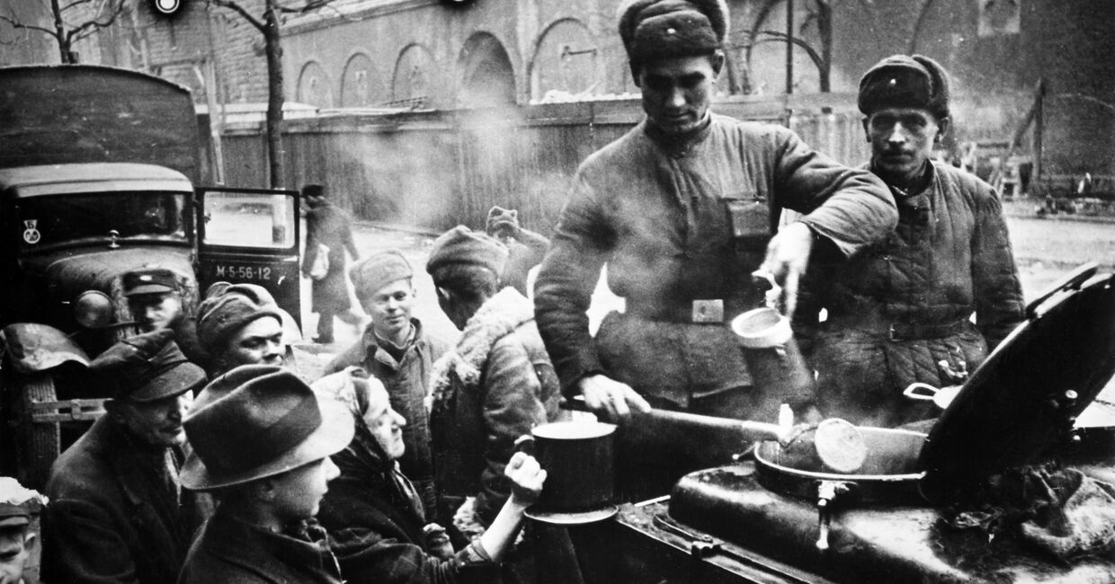 Великая Отечественная война. 1941-1945 гг. Советские солдаты раздают еду жителям Берлина. Германия. 1945 г.
