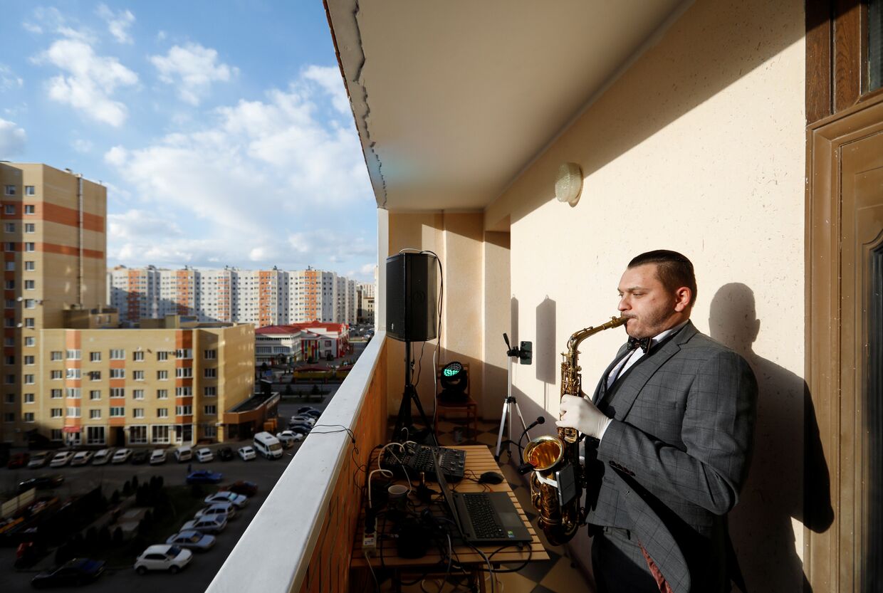 Саксофонист Игорь Ермошкин выступает на балконе жилого дома в Ставрополе