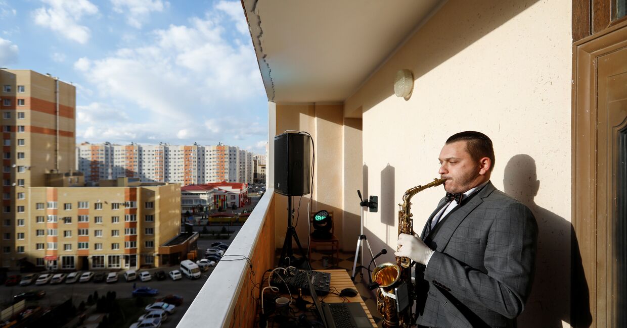 Саксофонист Игорь Ермошкин выступает на балконе жилого дома в Ставрополе