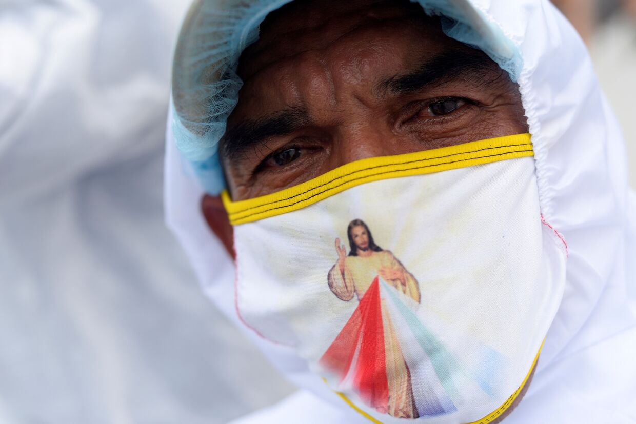 15 апреля 2020. Работник похоронной службы в маске с изображением Иисуса Христа, Гуаякиль, Эквадор